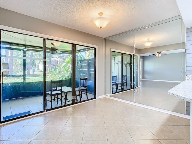 tiled empty room with a textured ceiling and ceiling fan