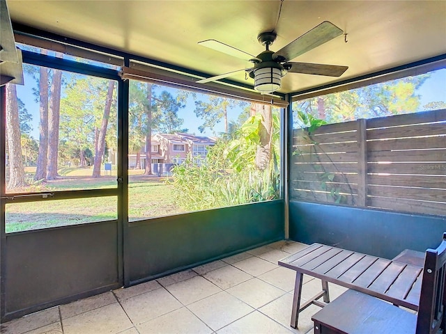 unfurnished sunroom with ceiling fan