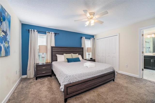 carpeted bedroom featuring ceiling fan, a textured ceiling, connected bathroom, and a closet