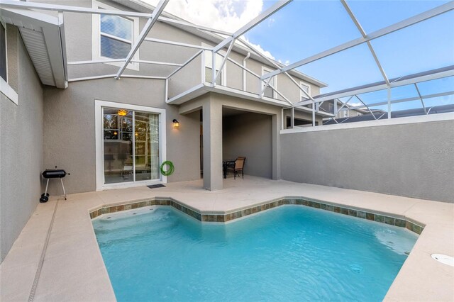 view of swimming pool featuring a lanai and a patio