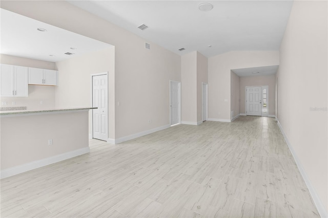 unfurnished living room featuring light hardwood / wood-style flooring and lofted ceiling