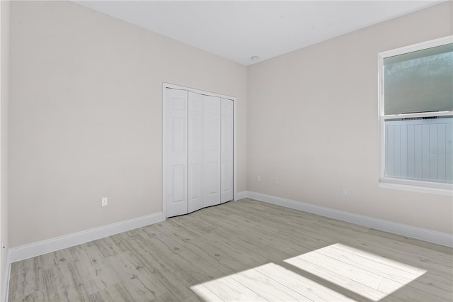 unfurnished bedroom with a closet and light hardwood / wood-style flooring