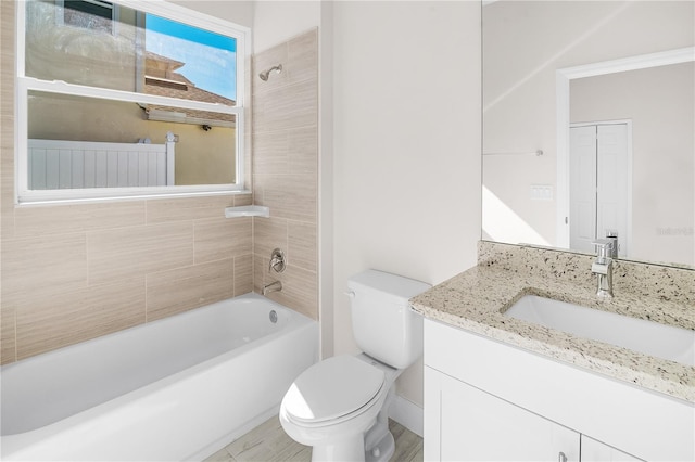 full bathroom with vanity, tiled shower / bath combo, toilet, and tile walls