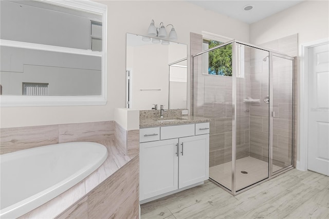 bathroom with vanity and shower with separate bathtub