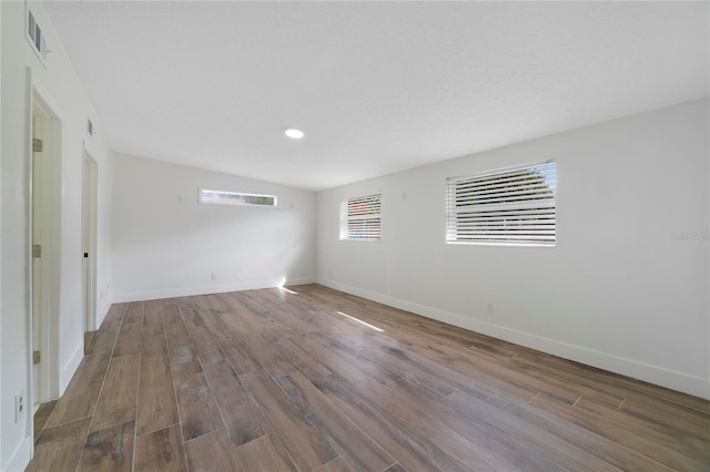 spare room featuring hardwood / wood-style flooring and lofted ceiling