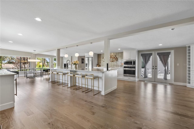 unfurnished living room featuring lofted ceiling, a textured ceiling, and hardwood / wood-style flooring