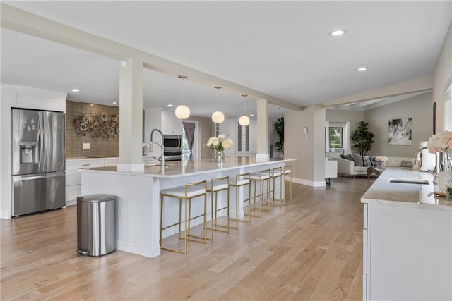 kitchen featuring light hardwood / wood-style floors, white cabinetry, sink, and appliances with stainless steel finishes