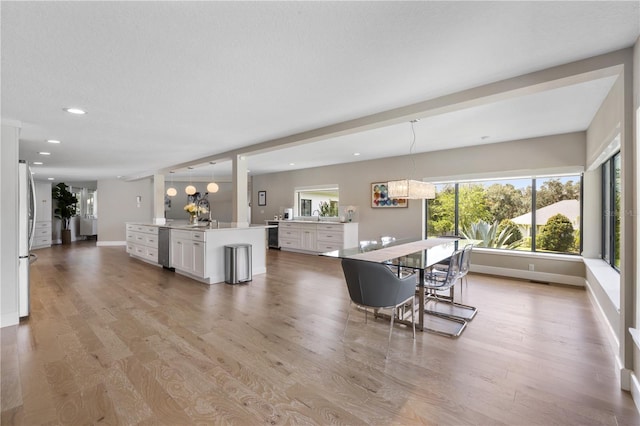 dining area featuring light hardwood / wood-style floors and a textured ceiling