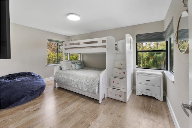 bedroom featuring multiple windows and light hardwood / wood-style flooring