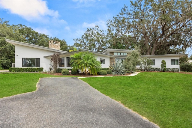 12550 Lakeshore Dr, Clermont, FL 34711 - view of front of home with a chimney, stucco siding, and a front yard