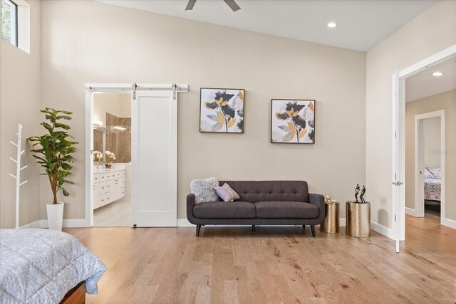 12550 Lakeshore Dr, Clermont, FL 34711 - bedroom featuring wood finished floors, a barn door, recessed lighting, and connected bathroom