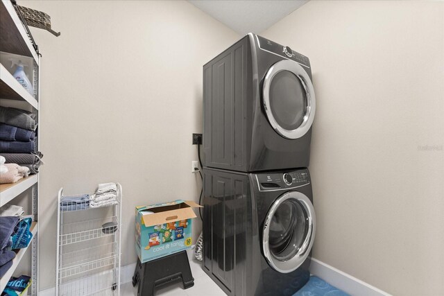 12550 Lakeshore Dr, Clermont, FL 34711 - washroom with stacked washer and clothes dryer and baseboards