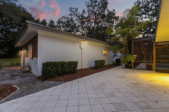 12550 Lakeshore Dr, Clermont, FL 34711 - property exterior at dusk with a patio and stucco siding