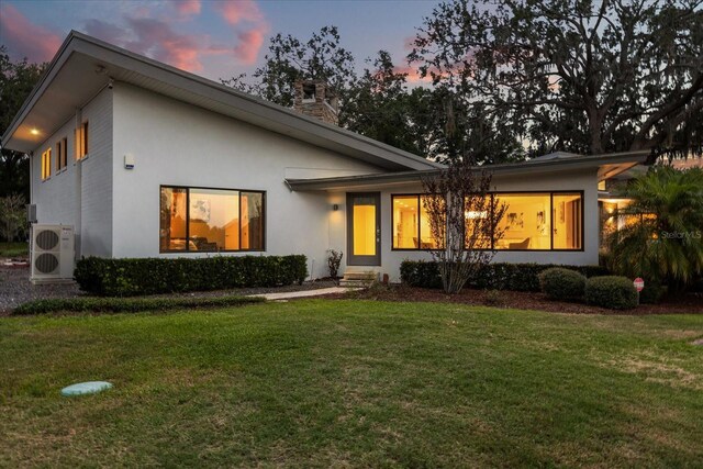 12550 Lakeshore Dr, Clermont, FL 34711 - view of front of property featuring stucco siding, a front lawn, and a chimney