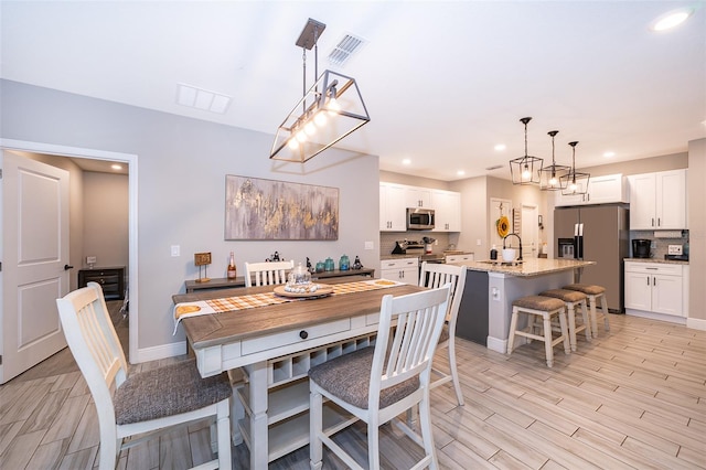 dining area featuring light hardwood / wood-style floors and sink