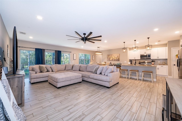 living room with ceiling fan and light hardwood / wood-style flooring