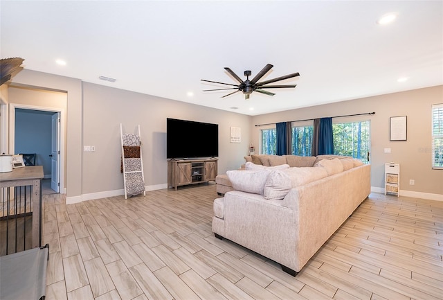 living room with ceiling fan and light hardwood / wood-style flooring