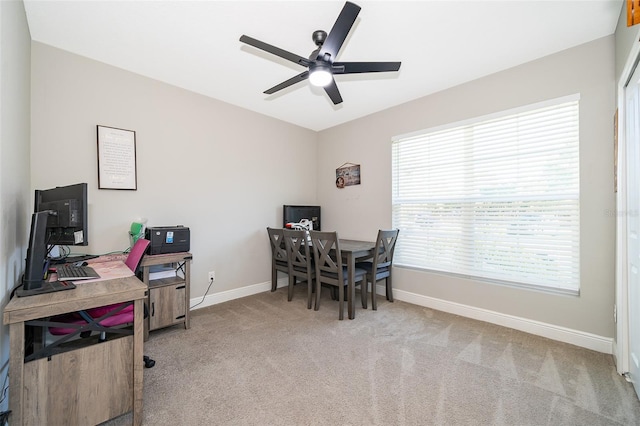 carpeted home office featuring ceiling fan