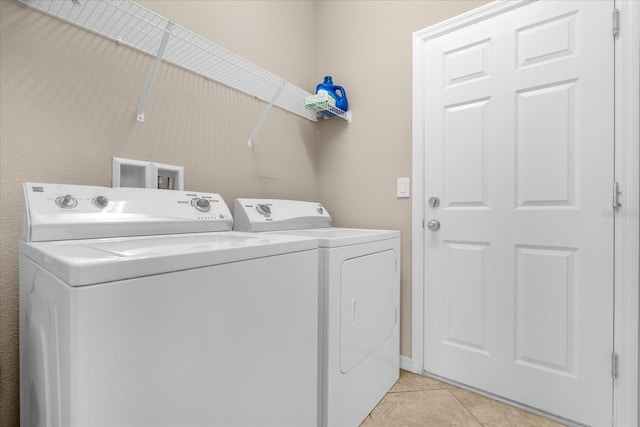 washroom featuring washer and clothes dryer and light tile patterned floors