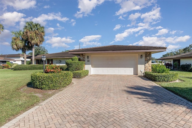 ranch-style house with a garage and a front lawn