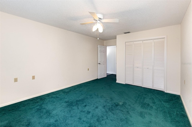 unfurnished bedroom with a textured ceiling, a closet, dark carpet, and ceiling fan