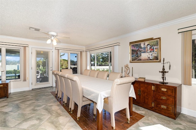 dining space featuring ornamental molding, a healthy amount of sunlight, and a textured ceiling