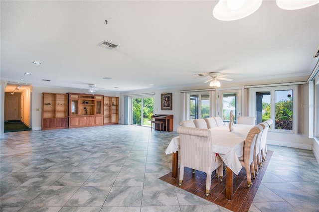 dining space with visible vents, ornamental molding, and a ceiling fan
