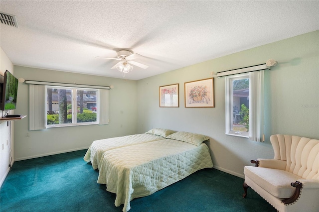 bedroom featuring visible vents, carpet, and a textured ceiling
