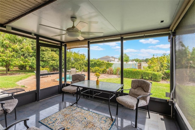 sunroom with outdoor dining space and a ceiling fan