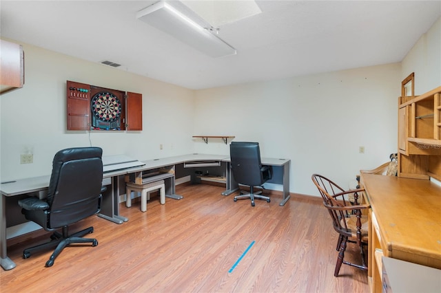 office area with baseboards, visible vents, and light wood-type flooring