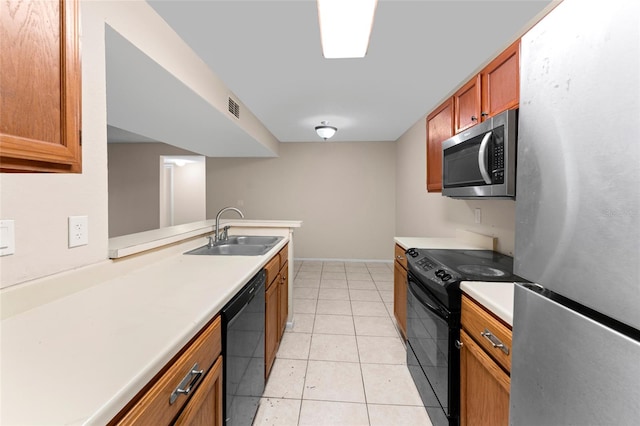 kitchen with black appliances, kitchen peninsula, light tile patterned floors, and sink