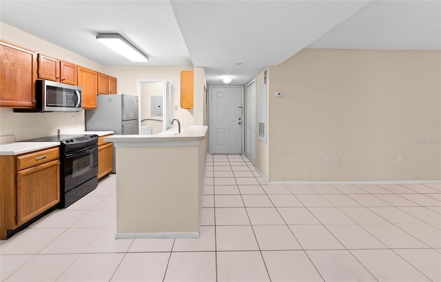 kitchen featuring light tile patterned flooring, stainless steel appliances, and a kitchen island with sink