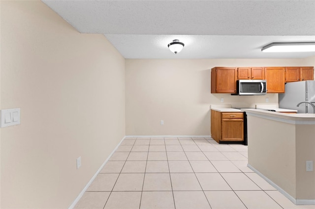 kitchen with sink, light tile patterned floors, a textured ceiling, and white refrigerator