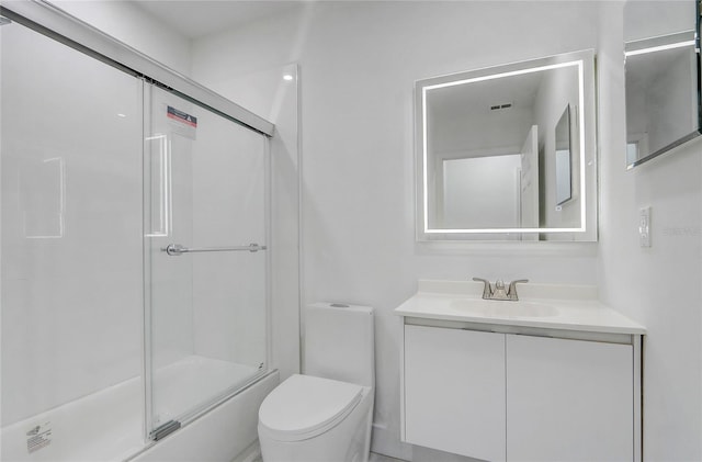 full bathroom with combined bath / shower with glass door, vanity, and toilet