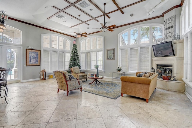 living room featuring ceiling fan, a towering ceiling, a healthy amount of sunlight, and coffered ceiling