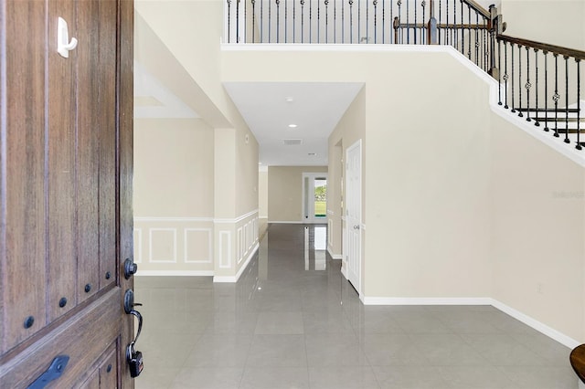 entryway featuring tile patterned flooring and a towering ceiling