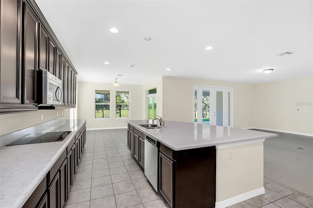 kitchen featuring a center island with sink, sink, stainless steel appliances, and a wealth of natural light