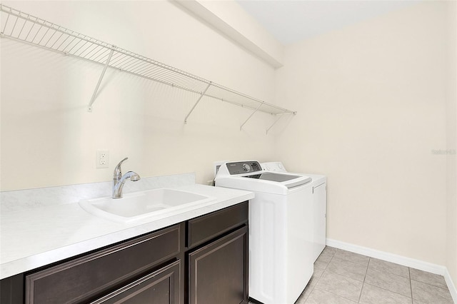 washroom featuring cabinets, light tile patterned floors, washing machine and dryer, and sink