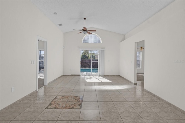 unfurnished room with ceiling fan, light tile patterned floors, a textured ceiling, and high vaulted ceiling