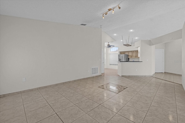 unfurnished living room featuring a textured ceiling, ceiling fan, lofted ceiling, and light tile patterned flooring