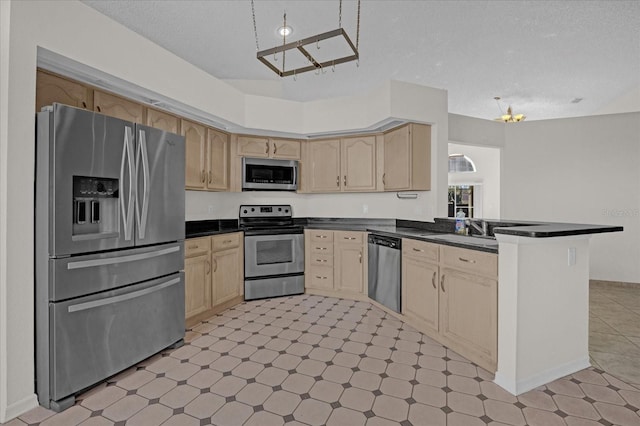 kitchen featuring kitchen peninsula, appliances with stainless steel finishes, a textured ceiling, and light brown cabinetry