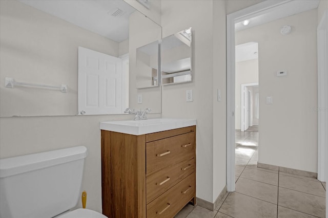 bathroom featuring tile patterned flooring, vanity, and toilet