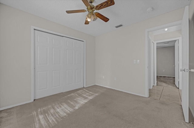 unfurnished bedroom with ceiling fan, light colored carpet, and a closet