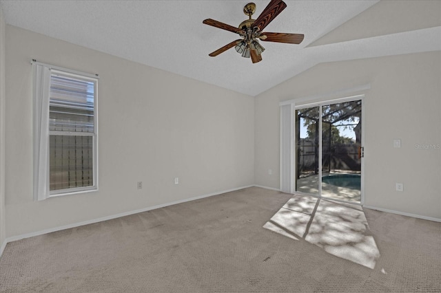 carpeted spare room with a textured ceiling, ceiling fan, and lofted ceiling