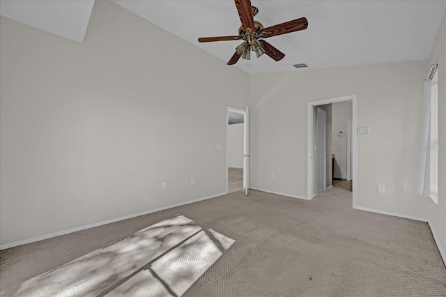 unfurnished bedroom featuring light colored carpet, vaulted ceiling, and ceiling fan