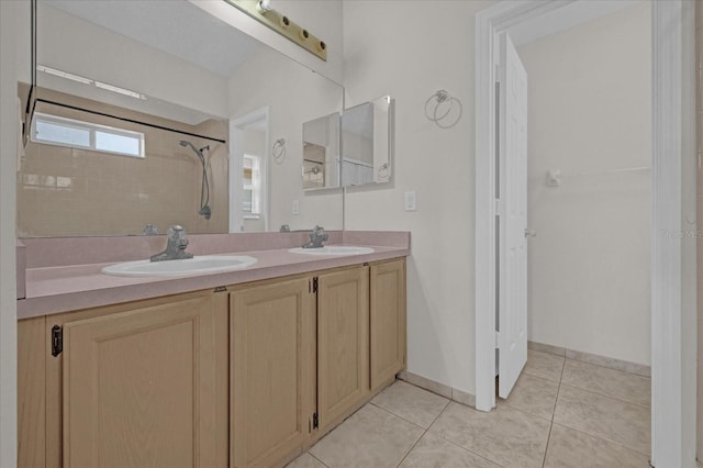 bathroom featuring a tile shower, vanity, and tile patterned floors