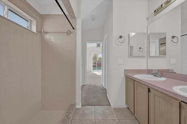 bathroom featuring vanity, tile patterned floors, a wealth of natural light, and vaulted ceiling