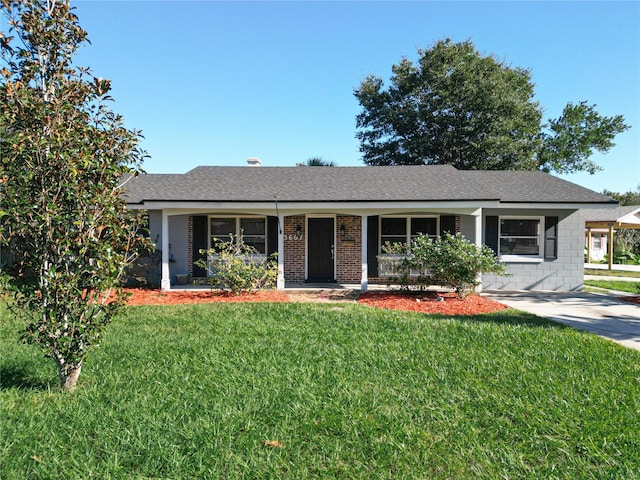 ranch-style house featuring covered porch and a front yard