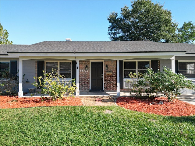 ranch-style house featuring covered porch and a front lawn