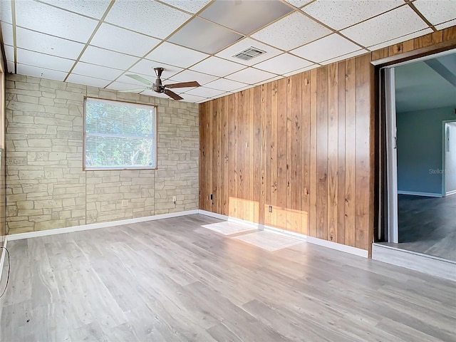 unfurnished room with hardwood / wood-style flooring, a drop ceiling, and ceiling fan